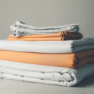 Home 7 Neatly folded stacks of freshly laundered sheets and linens