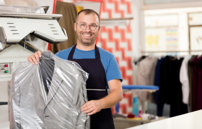 Home 15 Dry cleaning professional holding a freshly cleaned suit in a protective garment bag
