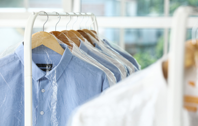 Home 13 Dress shirts hanging on wooden hangers inside protective garment covers