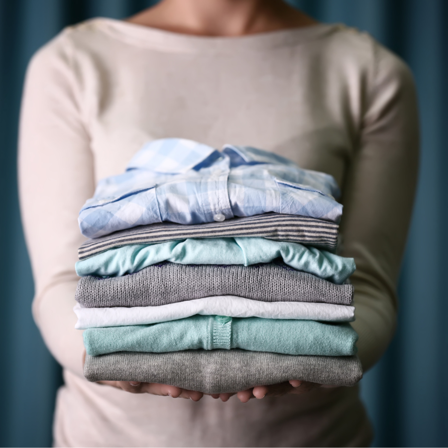 Wash & Fold 4 Professional wash and fold laundry service woman holding a stack of freshly folded shirts