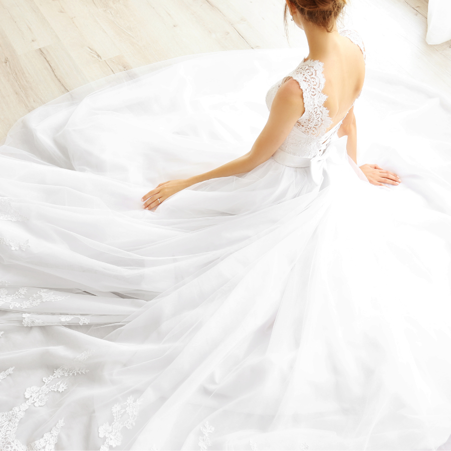Wedding Gown Cleaning & Preservation 5 Bride seated in a wedding gown with a long flowing train surrounding her